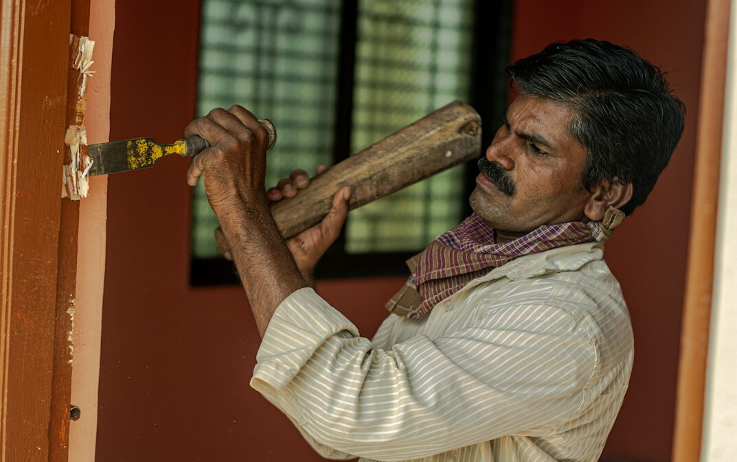 Technician inspecting a door frame with tools